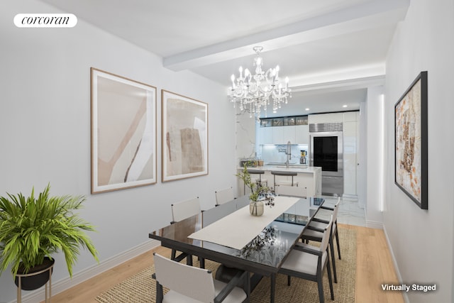 dining space featuring beamed ceiling, sink, an inviting chandelier, and light hardwood / wood-style flooring