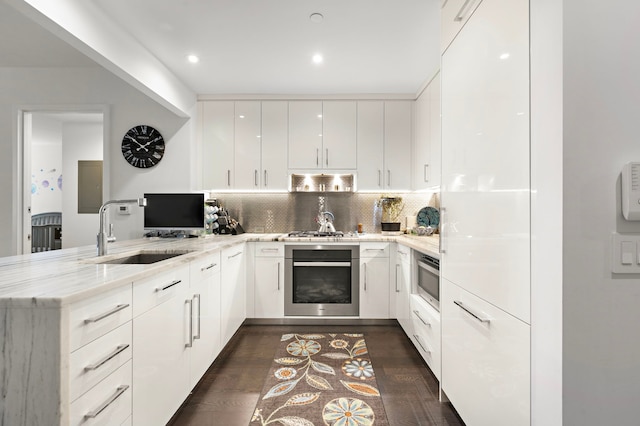 50 Riverside Blvd Unit 15-M, New York City, NY 10069 - kitchen with stainless steel appliances, a peninsula, a sink, light stone countertops, and modern cabinets