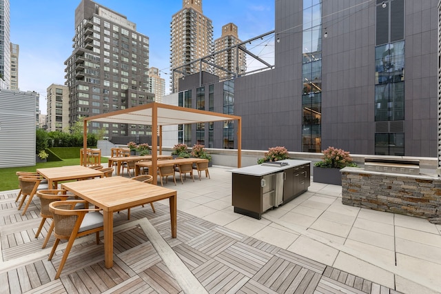view of patio / terrace with exterior kitchen, a city view, and outdoor dining space