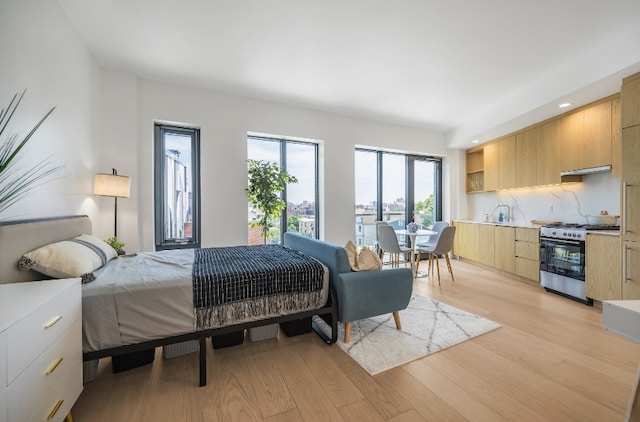 bedroom featuring sink and light hardwood / wood-style flooring