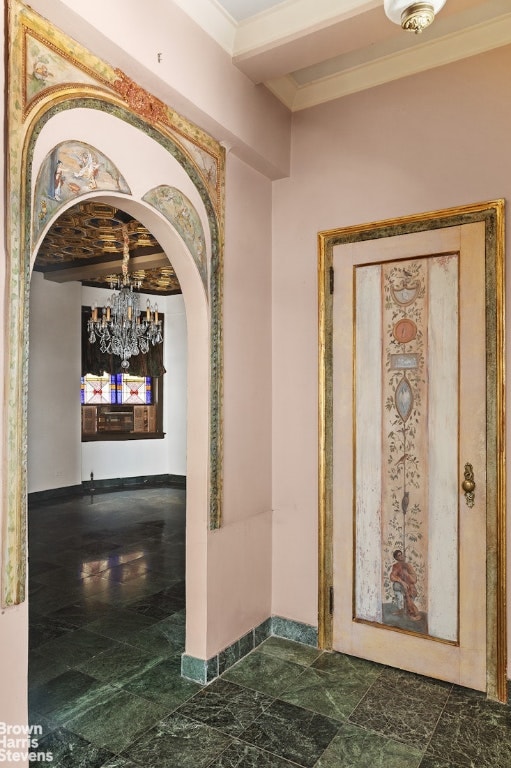 hallway featuring crown molding and a chandelier