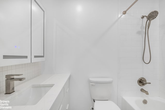 full bathroom with vanity, tiled shower / bath, decorative backsplash, and toilet