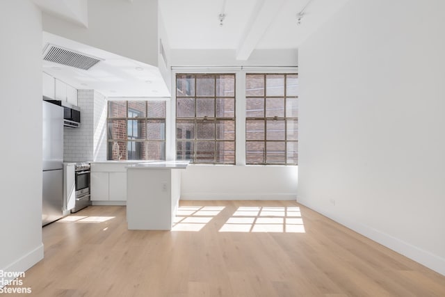 kitchen featuring stainless steel appliances, light wood-style flooring, visible vents, and white cabinetry