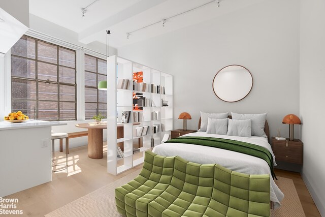 empty room with beamed ceiling, track lighting, and light hardwood / wood-style floors