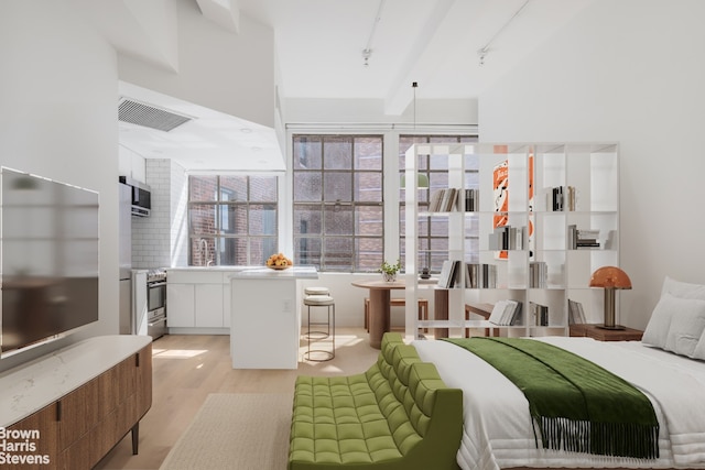 bedroom with visible vents, light wood-style flooring, and track lighting