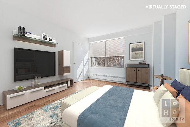 bedroom with radiator heating unit, a baseboard heating unit, and wood finished floors