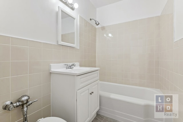 full bathroom featuring bathing tub / shower combination, vanity, and tile walls