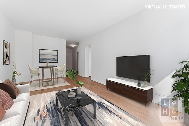 living room with baseboards and wood finished floors