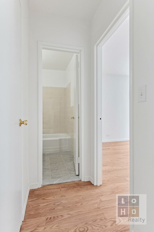 corridor with wood finished floors and baseboards