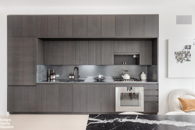 kitchen featuring tasteful backsplash, sink, gray cabinets, and stainless steel appliances