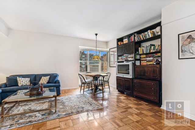 living area with cooling unit and baseboards