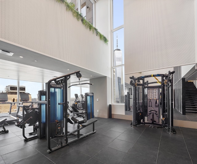 gym with a high ceiling and a wall of windows