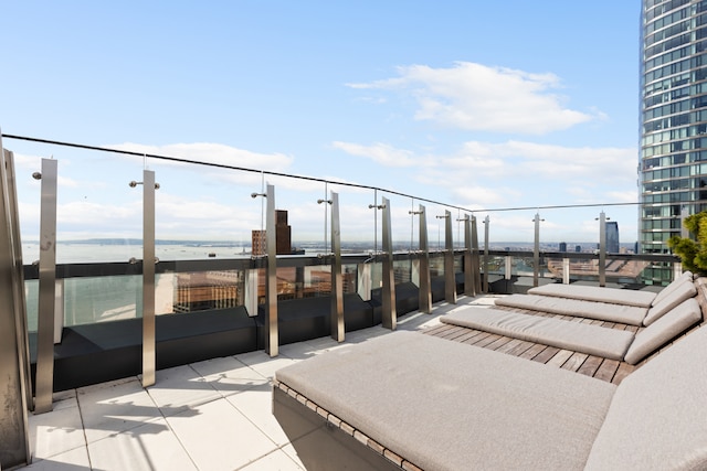 view of patio featuring a water view and a balcony