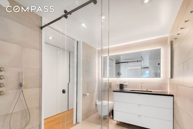 bathroom featuring vanity, tile walls, an enclosed shower, and toilet