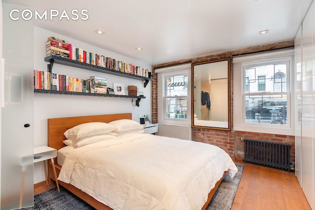 bedroom with hardwood / wood-style flooring and radiator