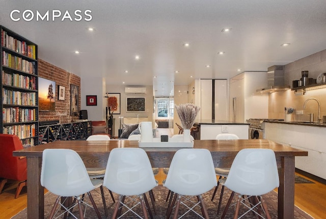 dining space featuring sink and a wall mounted air conditioner