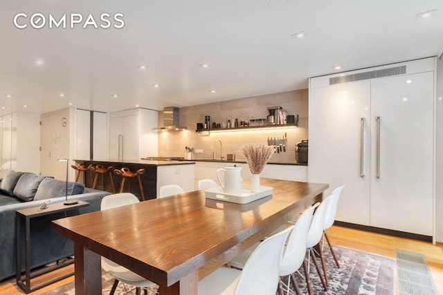 dining room featuring sink and light hardwood / wood-style flooring