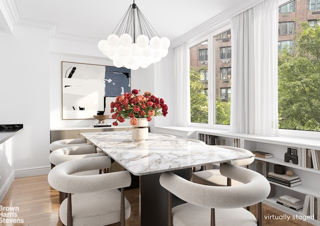 dining room with light wood-type flooring, a notable chandelier, baseboards, and crown molding