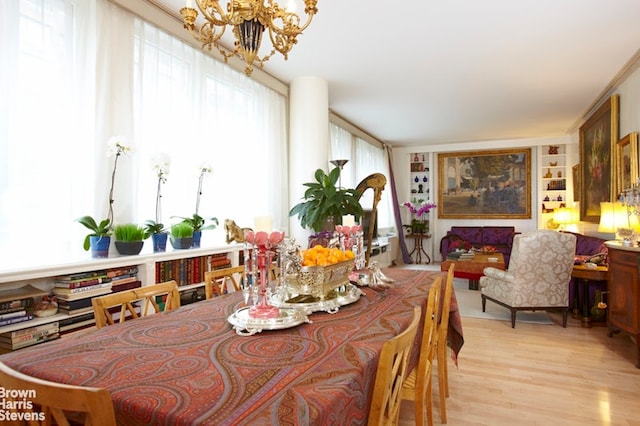 dining area featuring light wood-style flooring and a notable chandelier