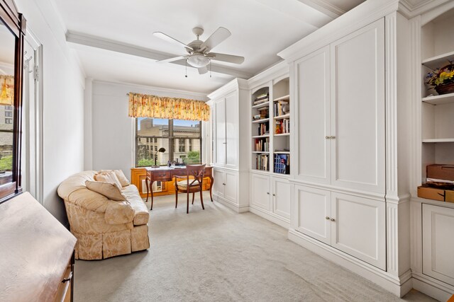 living area with ornamental molding, light colored carpet, built in features, and ceiling fan