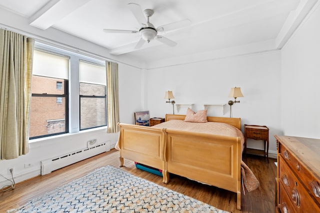 bedroom featuring ceiling fan, a baseboard radiator, and wood-type flooring