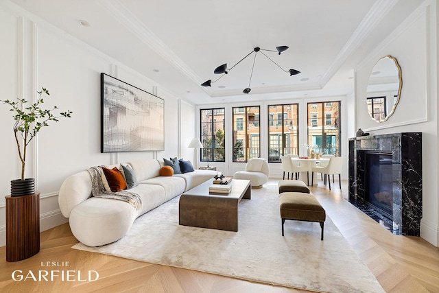 235 W 11th St, New York City, NY 10014 - living room with a raised ceiling, a chandelier, a fireplace, and ornamental molding