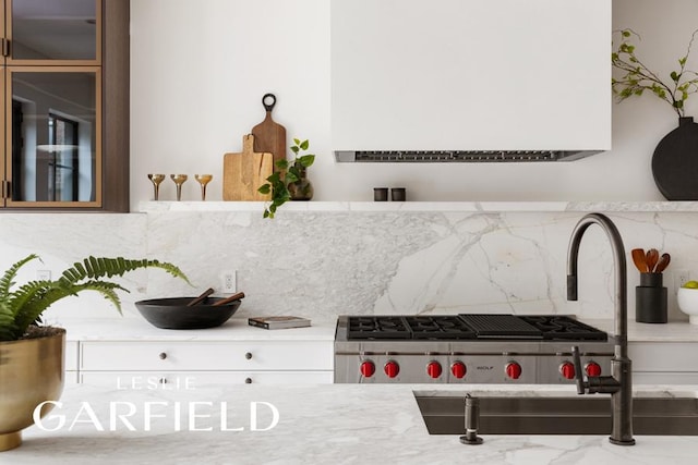 interior details with tasteful backsplash, light stone countertops, and sink