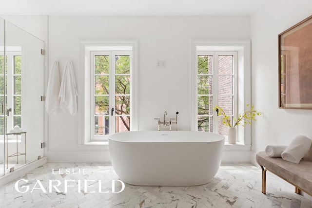 bathroom featuring plenty of natural light and separate shower and tub