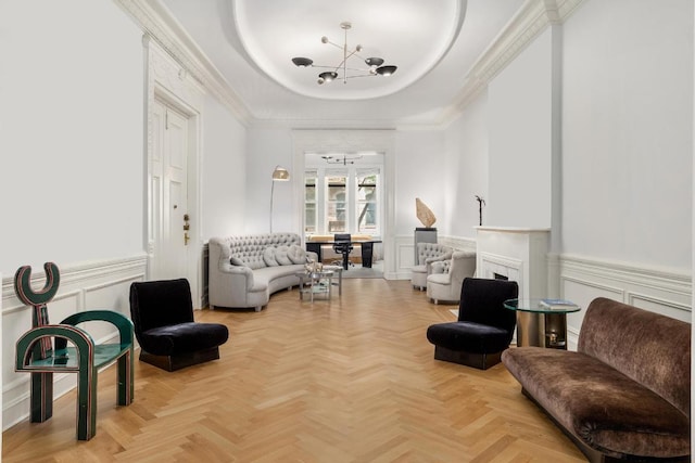 living area with a raised ceiling, light parquet flooring, crown molding, and an inviting chandelier