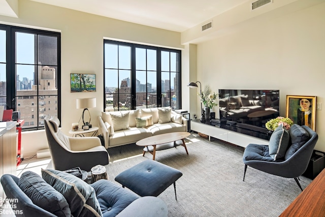 living area featuring a view of city, wood finished floors, and visible vents