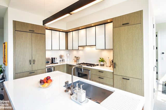 kitchen featuring beverage cooler, light countertops, a sink, and modern cabinets