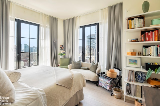 bedroom featuring a city view and wood finished floors