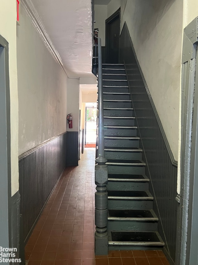 stairs with ornamental molding and wainscoting