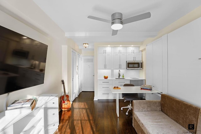 kitchen featuring sink, dark wood-type flooring, ceiling fan, tasteful backsplash, and white cabinets