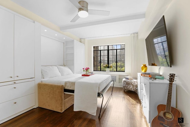 bedroom featuring beam ceiling, dark hardwood / wood-style flooring, ceiling fan, and a closet