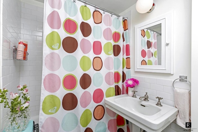 bathroom featuring a shower with shower curtain and sink