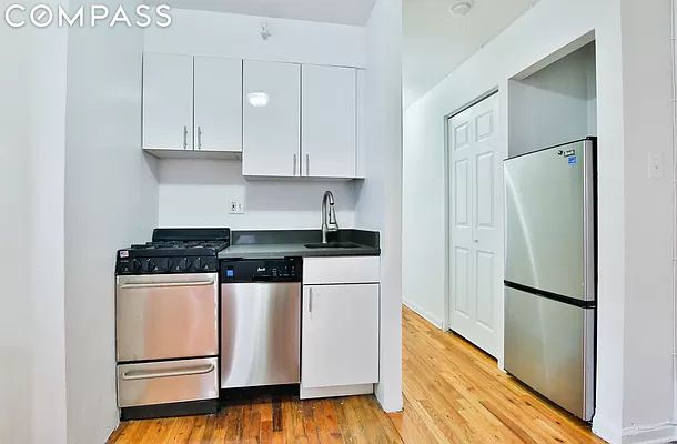 kitchen with white cabinetry, appliances with stainless steel finishes, sink, and light hardwood / wood-style floors