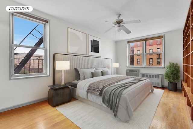 bedroom featuring radiator, ceiling fan, and light hardwood / wood-style flooring