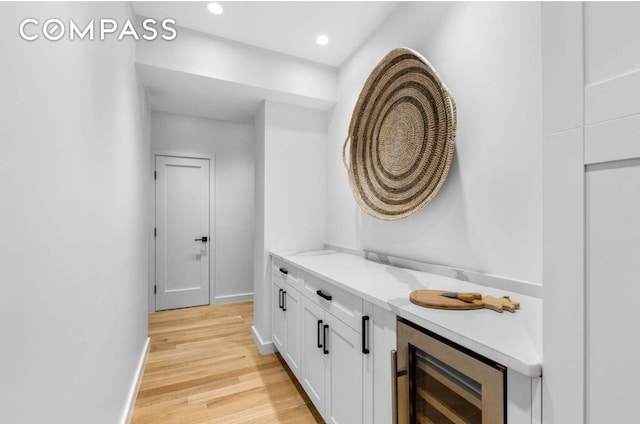 bathroom with recessed lighting, beverage cooler, baseboards, and wood finished floors