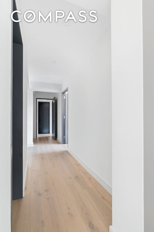 hallway with baseboards and light wood finished floors