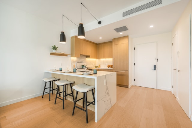 30-05 Vernon Blvd Unit 2-B, New York City, NY 11102 - kitchen with a peninsula, modern cabinets, light countertops, a kitchen breakfast bar, and light wood-style floors