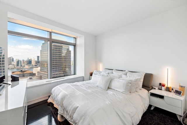 bedroom featuring a view of city and hardwood / wood-style floors