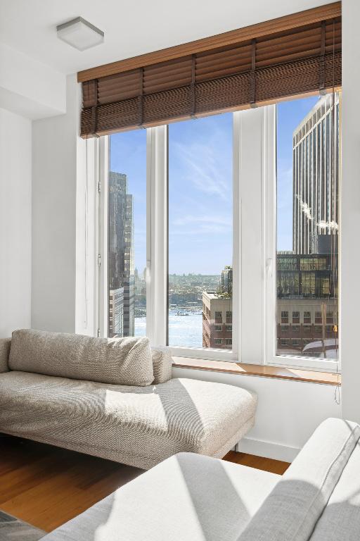 living room with a wealth of natural light, a water view, and wood-type flooring