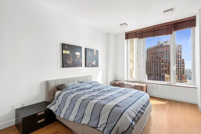 bedroom with light wood-type flooring and multiple windows