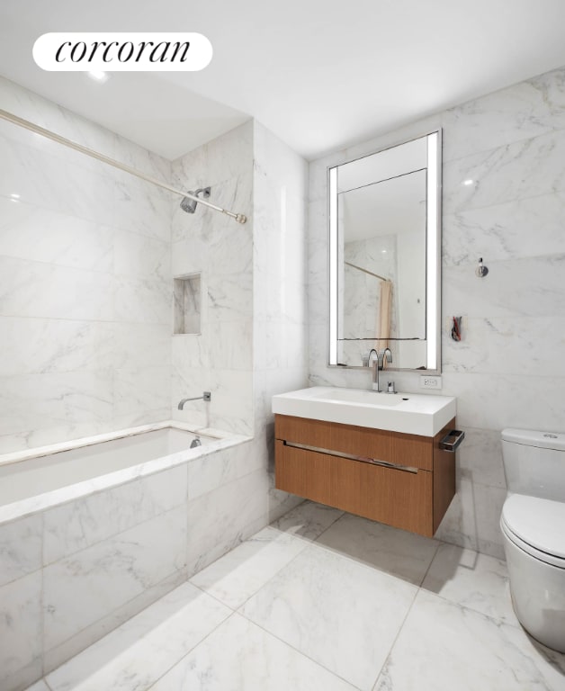 full bathroom featuring tile walls, toilet, vanity, and tiled shower / bath