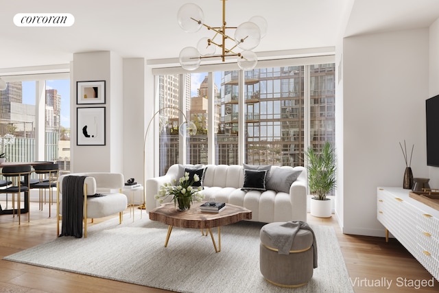 living area featuring a chandelier, wood finished floors, and baseboards
