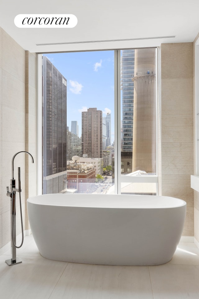 full bathroom featuring plenty of natural light, a soaking tub, floor to ceiling windows, and a skyline view