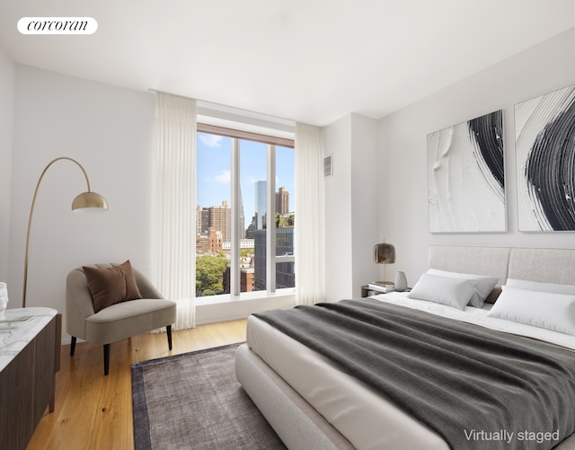 bedroom featuring light wood-style flooring and a view of skyline
