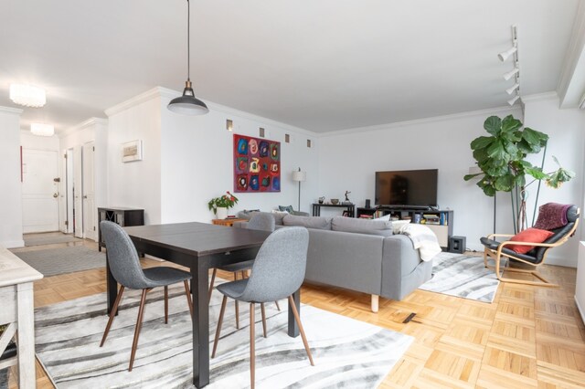 dining area featuring crown molding, parquet floors, and rail lighting