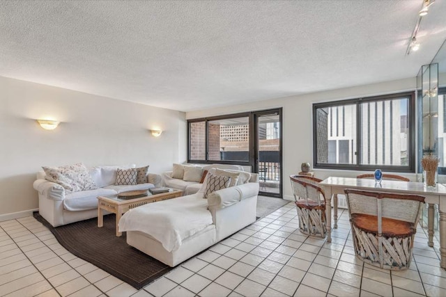 living room featuring a textured ceiling, track lighting, and light tile patterned flooring